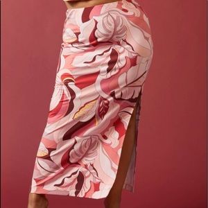 A bra knit maxi skirt featuring an allover tropical leaf print, with a leg slit.